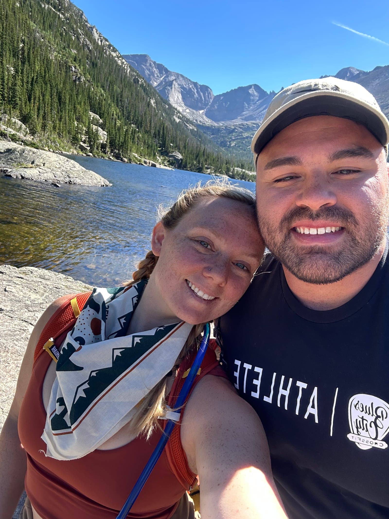 Dr. Hailey Andersen with her partner Isaiah on a hike by a mountain lake